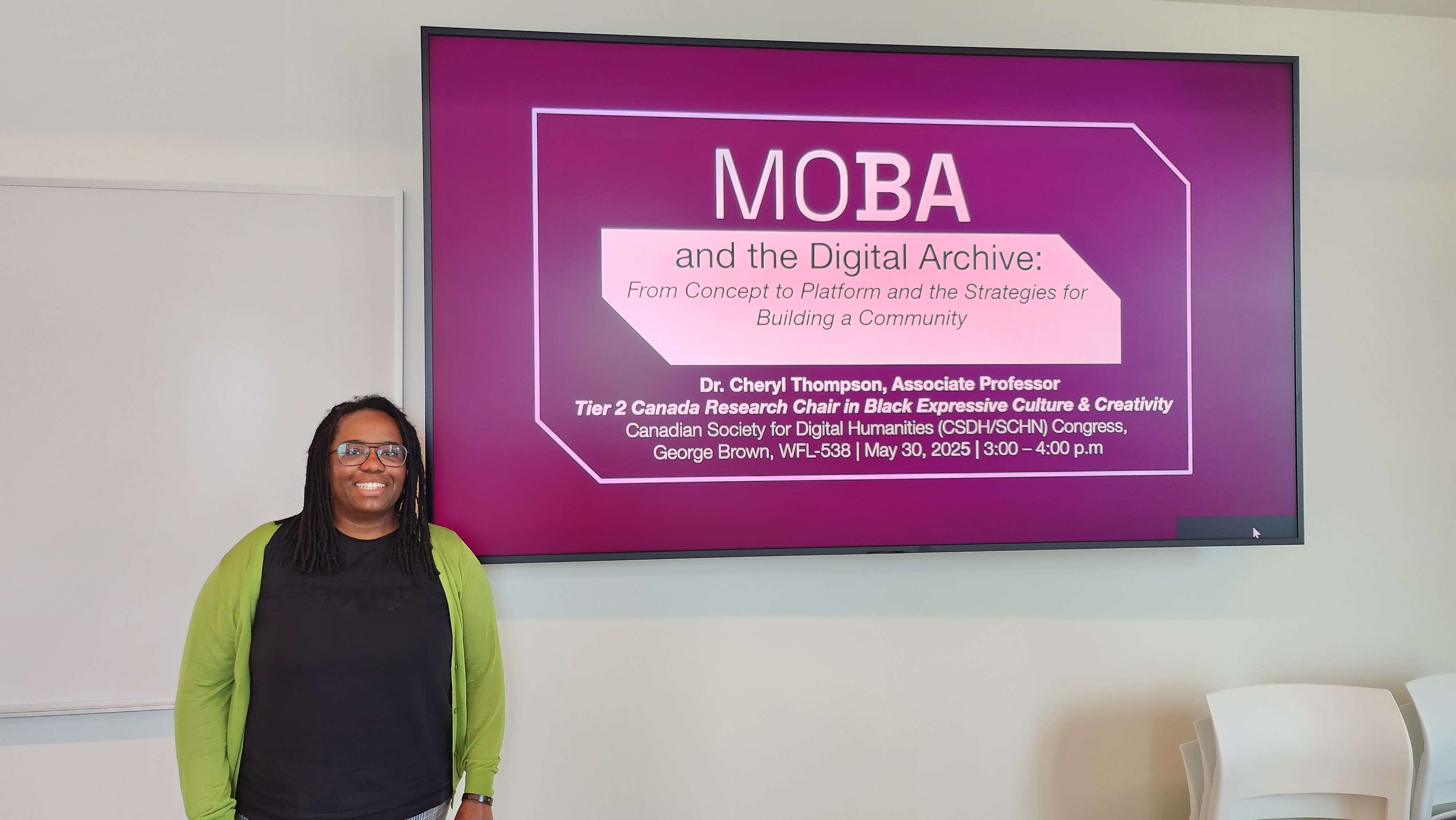 Dr. Cheryl Thompson standing in front of her plenary presentation.